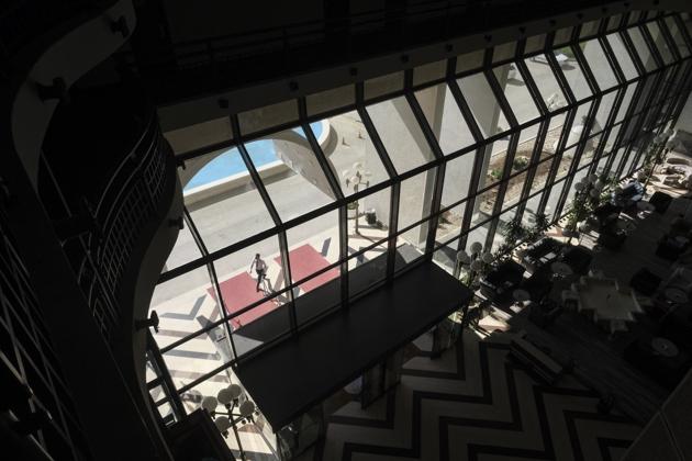 A man walks outside the Holiday Hotel, which opened as Holiday Inn, a luxurious accommodation for world's royalty, film stars and other dignitaries who came to watch the 1984 Winter Olympics, and less than a decade later, became ground zero of the bloody siege of Sarajevo in the 1990's, in Sarajevo, Bosnia, Wednesday, July 29, 2020. (AP)