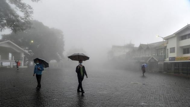 People wearing face masks cross an empty square at the Chowrasta Mall amid heavy fog during lockdown in Darjeeling on July 29. Despite daily cases rising by 50,000 for two days in a row now, there has also been a consistent trend of more than 30,000 recoveries being logged over the last eight days, HT reported. Average daily recoveries have risen from around 15,000 in the first week of July to around 35,000 in its last week. (Diptendu Dutta / AFP)