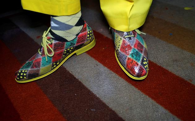 James Maina Mwangi displays his shoes as he poses for a photograph as he displays his attire comprising at least 160 suits with matching accessories including a mask to prevent the coronavirus disease (COVID-19) infection at his residence in Nairobi, Kenya July 30, 2020. (REUTERS)