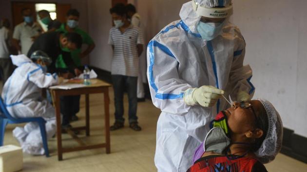 A Kolkata Municipal Corporation (KMC) health department worker collects a swab sample for COVID-19 testing in Kolkata on July 30. Most recent data available from the Union Health Ministry on July 30 shows that 1,057,805 people (64.5%) out of the total 1,638,870 infected across India have recovered from the disease while 335,747 have died. (Samir Jana / HT Photo)