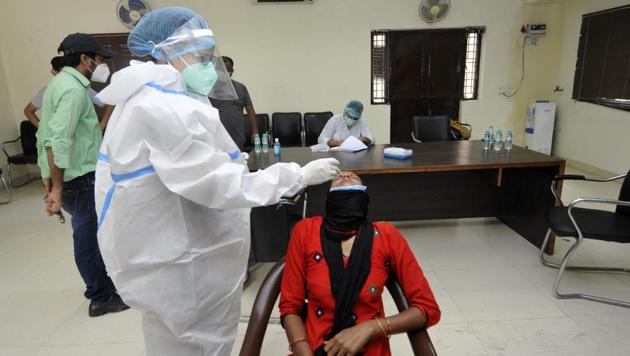 A health worker collects swab sample from a woman to test for coronavirus infection, at Sector 30, in Noida, UP, July 29, 2020.(Sunil Ghosh / HT Photo)