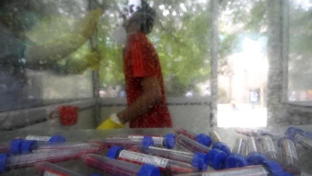 Swab samples collected for rapid antigen testing are pictured while a health worker in a kiosk collects attends to a person in Noida on July 30. The gap between recovered patients and the number of active cases has been a key statistic that highlights the ability of health care systems to cope with, and cure cases of Covid-19. (Sunil Ghosh / HT Photo)