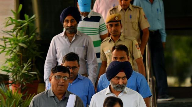 Former promoters of Religare Enterprises (REL) and the Fortis Healthcare hospital chain Shivinder Mohan Singh, his elder brother Malvinder Mohan Singh, and others being taken to court by Economic Offences Wing (EOW) of the Delhi Police officers for allegedly misappropriating funds at EOW office, Mandir Marg in New Delhi in 2019.(Amal KS/HT PHOTO)
