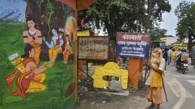 A devotee pays respect to a mural depicting paintings from the Ramayana, in Ayodhya on Thursday.(PTI Photo)