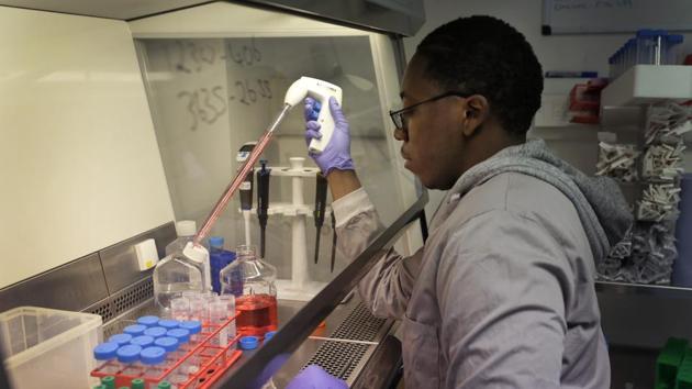 Leon McFarlane a research technician works with blood samples from volunteers in the laboratory at Imperial College in London, Thursday.(AP File Photo)