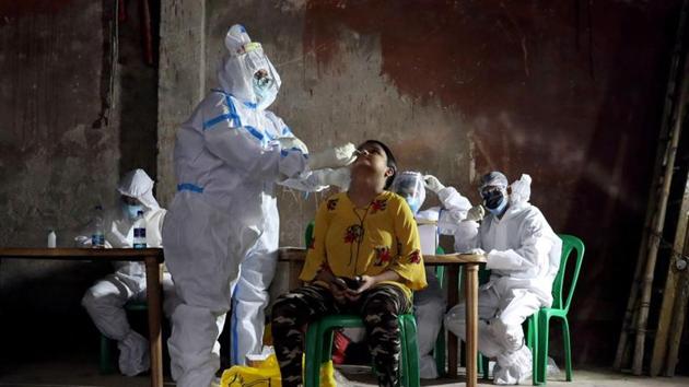 A healthcare worker wearing personal protective equipment (PPE) takes swab from a woman to test for the coronavirus disease in Kolkata. (REUTERS) A healthcare worker wearing personal protective equipment (PPE) takes swab from a woman to test for the coronavirus disease in Kolkata. (REUTERS)