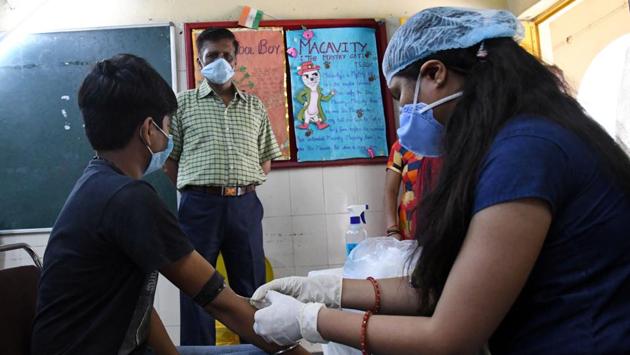 A medical personnel collects a blood sample under the “Community transmission surveillance programme" to conduct rapid antibody tests and calculate the transmission stage of Covid-19, in New Delhi on August 1. As one of the strategies to contain the spread of the pandemic, authorities have started the second serological survey for Covid-19 in Delhi where around 15,000 blood samples will be collected till August 5, HT reported. (HT Photo)
