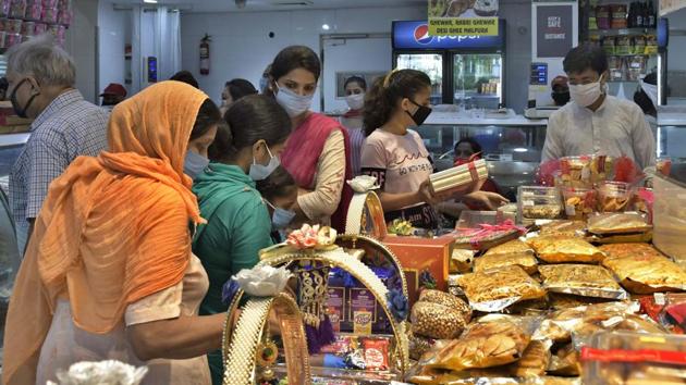 City residents purchasing sweets from a sweet shop ahead of Rakhi Festival in Ludhiana on Saturday. (Harsimar Pal Singh/HT) City residents purchasing sweets from a sweet shop ahead of Rakhi Festival in Ludhiana on Saturday. (Harsimar Pal Singh/HT)