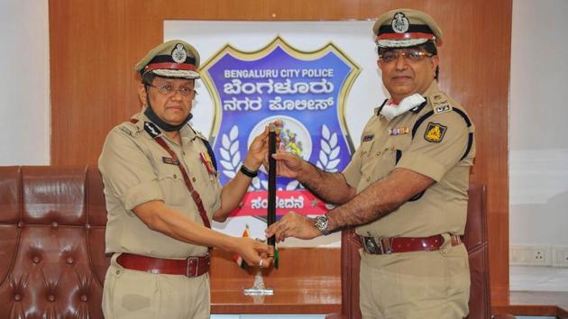 Outgoing Police Commissioner Bhaskar Rao (R) hands over a baton to the newly appointed Bengaluru City Police Commissioner Kamal Pant at commissioner office, in Bengaluru, Saturday, Aug. 1, 2020.(PTI photo)