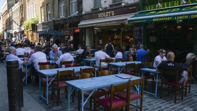 Public sit at the outside tables of restaurants in Soho, in London on Friday.(AP Photo)