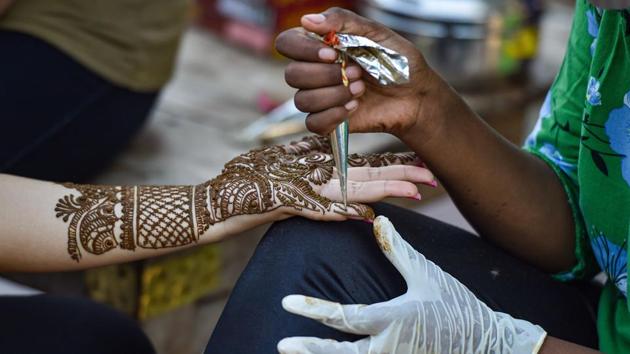 New Delhi: A woman gets her palms and arms decorated with 'mehndi' on the eve of Raksha Bandhan festival, during Unlock 3.0, in New Delhi, Sunday, Aug 2, 2020. (PTI Photo/Manvender Vashist)(PTI02-08-2020_000108A) (PTI)