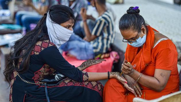 A woman gets her palms and arms decorated with 'mehndi' on the eve of Raksha Bandhan festival, during Unlock 3.0, in New Delhi, Sunday. (PTI Photo/Manvender Vashist)