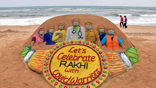 View of a sand sculpture with a message, 'Let's celebrate Rakhi with Covid Warriors', created by artist Sudarshan Pattnaik, on the eve of Raksha Bandhan festival, in Puri. (PTI)