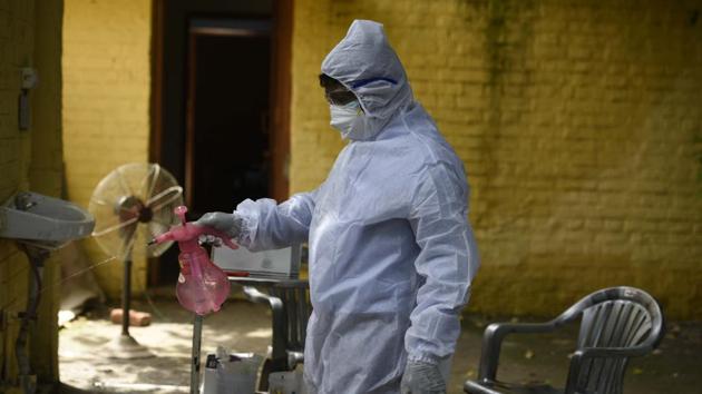A health worker sanitizes a premises during a coronavirus testing drive.(Parveen Kumar/HT file photo)