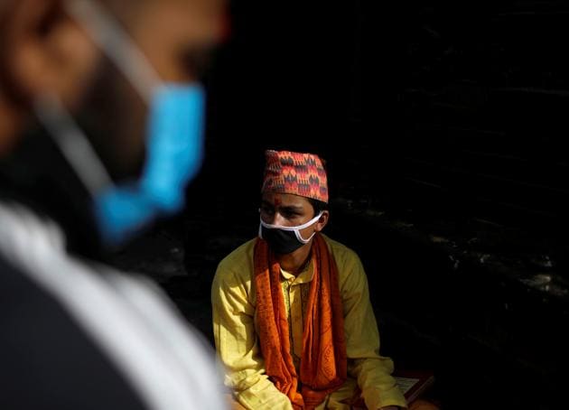 A Hindu priest wearing a face mask waits for devotees during the Janai Purnima festival (Sacred Thread Festival) at Pashupatinath Temple amid the outbreak of the coronavirus disease (COVID-19) in Kathmandu, Nepal, August 3, 2020. Hindus take holy baths and change their sacred thread, also known as Janai, for protection and purification, during the festival. (REUTERS)