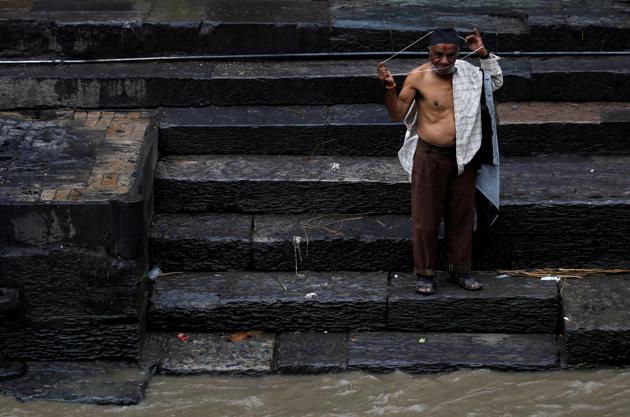 A devotee wears a new sacred thread during the Janai Purnima festival (Sacred Thread Festival) at Pashupatinath Temple in Kathmandu, Nepal, August 3, 2020. Hindus take holy baths and change their sacred thread, also known as Janai, for protection and purification, during the festival. (REUTERS)
