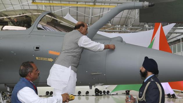Defence Minister Rajnath Singh writes onto a Rafale jet fighter as a ritual gesture during an handover ceremony at the Dassault Aviation plant in Merignac, near Bordeaux, southwestern France.(AP) Defence Minister Rajnath Singh writes onto a Rafale jet fighter as a ritual gesture during an handover ceremony at the Dassault Aviation plant in Merignac, near Bordeaux, southwestern France.(AP)