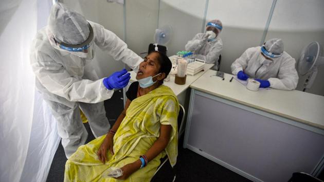 A health worker collects swab sample to test for Covid-19 at the Indo-Israel Non-Invasive Raid Covid-19 test study camp as part of Operation Open Skies, at Dr Ram Manohar Lohia Hospital, in New Delhi on July 31. As infections continue to surge in the country, having registered a record of 57,118 on August 1, India has also stepped up efforts to test more people and search for a vaccine. (Biplov Bhuyan / HT Photo)