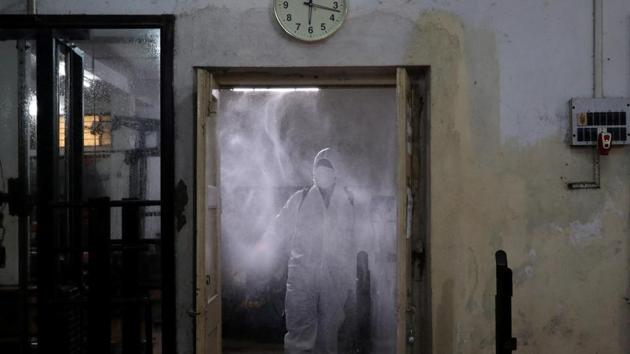 A worker wearing personal protective equipment (PPE) sanitizes a gym cum yoga centre before its reopening after authorities eased lockdown restrictions that were imposed to slow the spread of the coronavirus disease (COVID-19), in Kolkata. (REUTERS)