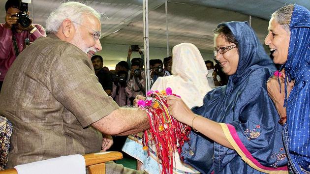 In this file picture from 2015, women are seeing tying Rakhi on the wrists of PM Narendra Modi.(PTI File Photo)