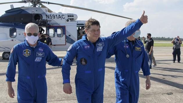 NASA astronaut Robert Behnken gives a thumbs-up to onlookers on the way to board a plane at Naval Air Station Pensacola in Florida on August 2. “There’s something special about having that capability to launch and bring your own astronauts home,” Behnken said while addressing a socially distant welcome ceremony. Behnken and Hurley returned after spending 64 days in space. (Bill Ingalls / NASA via AP)