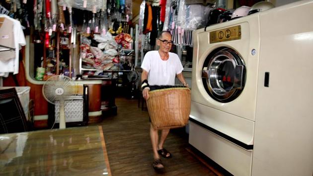 Chang Wan-ji works inside the laundry store he has run for decades with his wife in Taichung on July 30. Chang Wan-ji, 83, and his wife Hsu Sho-er, 84, have racked up nearly 600,000 followers on Instagram over the last month as their attitude-filled fashion portraits went viral. They have even been featured in the Taiwanese edition of Vogue and Marie Claire. (Hsu Tsun-hsu / AFP)