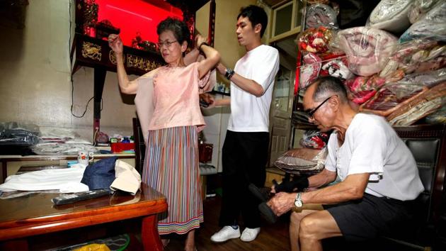 Reef Chang, 31, helps his grandparents get ready for a photo shoot at their laundry store on July 30. The couple’s grandson hit upon the idea of using the clothes to alleviate the couple’s boredom. “My grandpa and grandma were staring blankly at the streets because business wasn’t good,” he told AFP. “I wanted to find something new they could enjoy doing.” (Hsu Tsun-hsu / AFP)