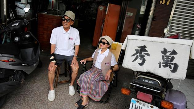 Chang Wan-ji and his wife Hsu Sho-er pose for photographs at their laundry store on July 30. The couple’s worldwide fame has also prompted a few forgetful customers to pick up old clothes, while some local fans have started visiting their sleepy town to see the store. The shop is named “Wan Sho” -- a combination of the middle character of their Chinese names. (Hsu Tsun-hsu / AFP)