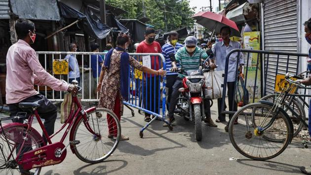People pass through a street leading to a market barricaded by authorities for crowd control in Kolkata on August 2. According to the Health Ministry, the Covid-19 recovery rate stands at 65.77%, while the Case Fatality Rate (CFR) is at 2.11% as on August 3. The ministry attributed this to an “effective containment strategy, aggressive testing and standardised clinical management protocols,” in a statement on August 2. (Bikas Das / AP)