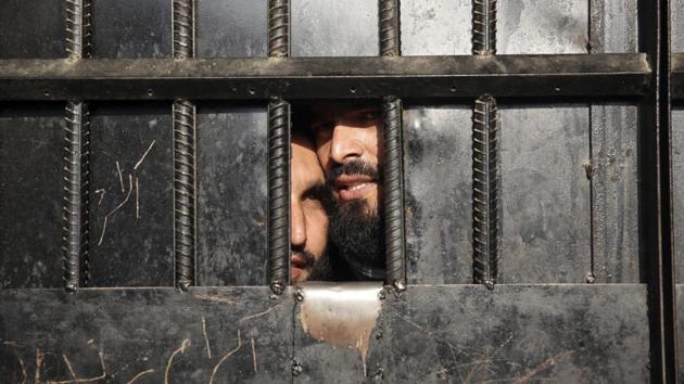 Taliban prisoners watch through the door inside the prison after an attack in the city of Jalalabad, east of Kabul, Afghanistan, Monday, Aug. 3, 2020.(AP photo)