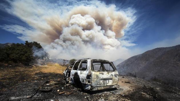 A burned car is seen as smoke rises from a brush fire at Cherry Valley in California on August 1. There have been no reports of casualties so far but experts claim that this is Southern California’s biggest blaze this year as the fire is still raging, AFP reported. (Ringo H.W. Chiu / AP)