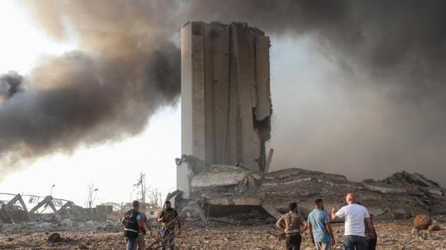 Residents gather by damaged buildings following a large explosion at the Port of Beirut in Beirut, Lebanon.(Bloomberg) Residents gather by damaged buildings following a large explosion at the Port of Beirut in Beirut, Lebanon.(Bloomberg)