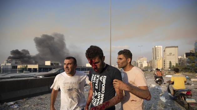 People help a man wounded in a massive explosion in Beirut, Lebanon.(AP)