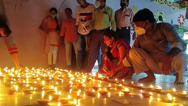 People light earthen lamps on the eve of the foundation laying ceremony of Ram Temple in Ayodhya on Tuesday.(ANI)