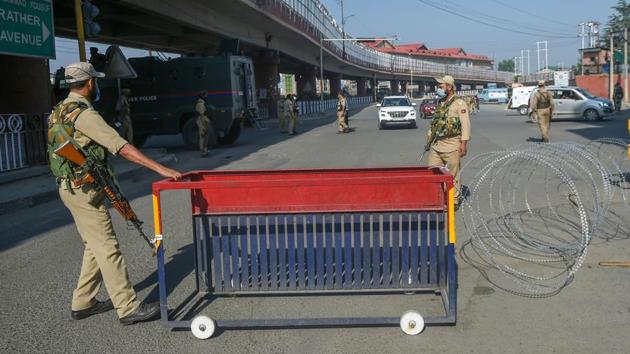 Security personnel place a barricade on a street during the restrictions imposed on the first anniversary of revocation of the special status of Jammu and Kashmir, in Srinagar on Wednesday.(PTI Photo) Security personnel place a barricade on a street during the restrictions imposed on the first anniversary of revocation of the special status of Jammu and Kashmir, in Srinagar on Wednesday.(PTI Photo)