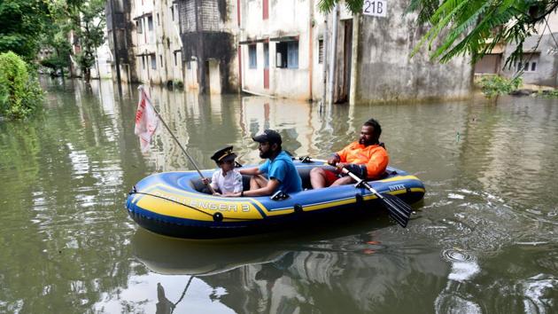 Air India employees enjoy in flooded water during heavy rain at Air India colony in Mumbai.(Satish Bate/HT Photo)