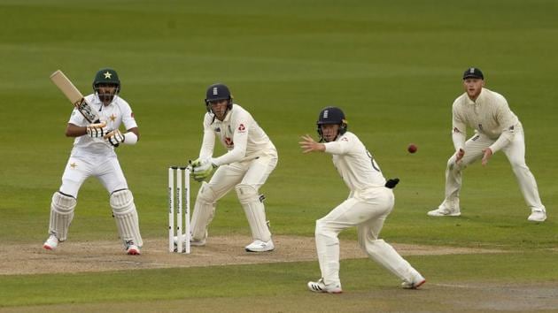 Pakistan's Babar Azam, left, plays a shot during the first day of the first cricket Test match between England and Pakistan at Old Trafford in Manchester, England, Wednesday, Aug. 5, 2020. (Lee Smith/Pool via AP) (AP)