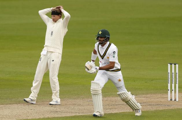 England's captain Joe Root, left, reacts as Pakistan's Shan Masood, right, runs between the wickets to score during the first day of the first cricket Test match between England and Pakistan at Old Trafford in Manchester, England, Wednesday, Aug. 5, 2020. (Lee Smith/Pool via AP) (AP) England's captain Joe Root, left, reacts as Pakistan's Shan Masood, right, runs between the wickets to score during the first day of the first cricket Test match between England and Pakistan at Old Trafford in Manchester, England, Wednesday, Aug. 5, 2020. (Lee Smith/Pool via AP) (AP)