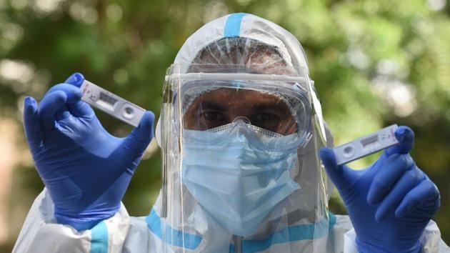 A health worker shows COVID-19 rapid antigen test kits in New Delhi on August 2. Active cases of the coronavirus disease (COVID-19) in Delhi dropped below the 10,000 mark for the first time in over two months on August 4, the same day that the number of daily deaths also touched a two-month low — highlighting progress made by the Capital in its fight against the pandemic. (Sonu Mehta / HT Photo)