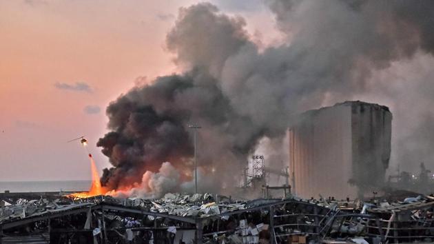 A helicopter puts out a fire at the scene of the explosion at the port in Beirut on August 4. The blast destroyed numerous buildings, leaving large numbers of people homeless at a time when many Lebanese have lost their jobs and are in the middle of currency crisis. The explosion also raises concerns about how Lebanon will continue to import nearly all of its vital goods with its main port devastated, the AP reported. (AFP) A helicopter puts out a fire at the scene of the explosion at the port in Beirut on August 4. The blast destroyed numerous buildings, leaving large numbers of people homeless at a time when many Lebanese have lost their jobs and are in the middle of currency crisis. The explosion also raises concerns about how Lebanon will continue to import nearly all of its vital goods with its main port devastated, the AP reported. (AFP)