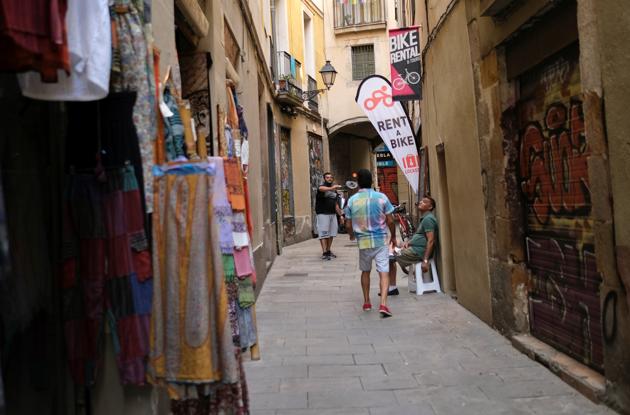Souvenirs shop and bike rental owners play on a street as they wait for tourists, after Catalonia's regional authorities announced restrictions to contain the spread of the coronavirus disease (COVID-19) in Barcelona, Spain August 4, 2020. (REUTERS)