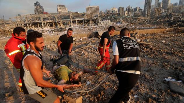 Firefighters and locals evacuate a wounded man from the explosion scene at the port in Beirut on August 4. Prime Minister Hassan Diab, in a short televised speech, has appealed to all countries and friends of Lebanon to extend help to the small nation, saying: “We are witnessing a real catastrophe.” (Anwar Amro / AFP) Firefighters and locals evacuate a wounded man from the explosion scene at the port in Beirut on August 4. Prime Minister Hassan Diab, in a short televised speech, has appealed to all countries and friends of Lebanon to extend help to the small nation, saying: “We are witnessing a real catastrophe.” (Anwar Amro / AFP)