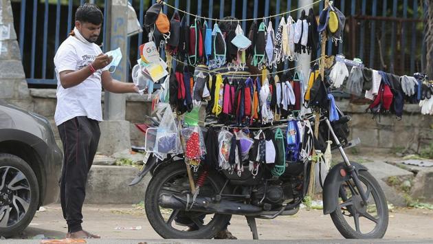 A man checks a face mask before buying it in Hyderabad on August 4. According to the health ministry’s dashboard, 1,282,215 patients—51,706 people between August 3 and August 4 morning—have been cured of the viral disease and the recovery rate stands at 67.19%. The recovered cases in India are now double the active cases. (Mahesh Kumar A. / AP)