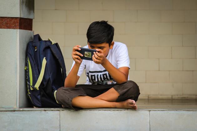 A boy engrossed in a game on his cellphone.(Shutterstock)