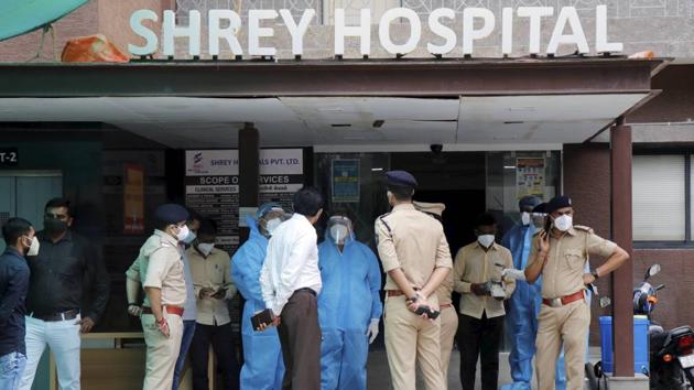 Forensic experts interact with police personnel while inspecting Shrey hospital after a major fire broke out in it in the wee hours, in Ahmedabad. (PTI)