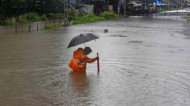 A Mumbai Suburban Railway staff measures the water level at Chunabhatti railway station in Mumbai on August 4. According to the Brihanmumbai Municipal Corporation (BMC), Mumbai recorded 215.8 mm of rain, followed by 101.9 mm in the eastern suburbs and 76.03 mm in the western suburbs. (Vijayanand Gupta / HT Photo)