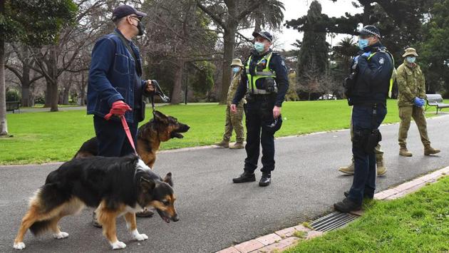 Police officers and soldiers patrol Treasury Gardens as they enforced strict lockdown laws in Melbourne on August 5. After closing its international borders early, locking down cities and launching a campaign of mass virus testing, Australia had reopened in June with daily cases in the single figures. (William West / AFP) Police officers and soldiers patrol Treasury Gardens as they enforced strict lockdown laws in Melbourne on August 5. After closing its international borders early, locking down cities and launching a campaign of mass virus testing, Australia had reopened in June with daily cases in the single figures. (William West / AFP)