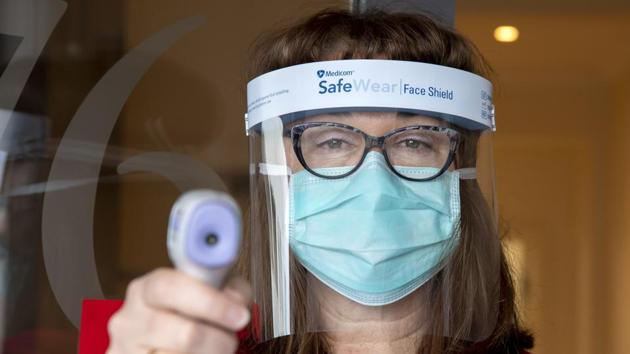 A medical staff holds up an infrared thermometer while screening people in Melbourne on August 6. Hidden transmissions among staff at quarantine centres however, led to wider community transmissions in Victoria, which has recorded triple-digit new cases for weeks, Reuters reported. (Andy Brownbill / AP) A medical staff holds up an infrared thermometer while screening people in Melbourne on August 6. Hidden transmissions among staff at quarantine centres however, led to wider community transmissions in Victoria, which has recorded triple-digit new cases for weeks, Reuters reported. (Andy Brownbill / AP)
