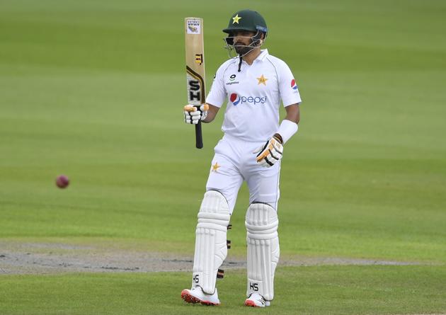 Pakistan's Babar Azam raises his bat to celebrate scoring fifty runs during the first day of the first cricket Test match between England and Pakistan at Old Trafford in Manchester, England, Wednesday, Aug. 5, 2020. (Dan Mullan/Pool via AP) (AP)