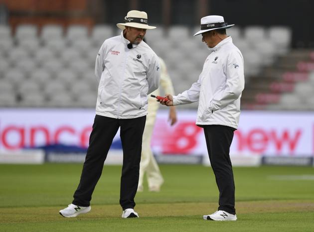 Umpires use a light meter after bad light stopped play on the first day of the first cricket Test match between England and Pakistan at Old Trafford in Manchester, England, Wednesday, Aug. 5, 2020. (Dan Mullan/Pool via AP) (AP)